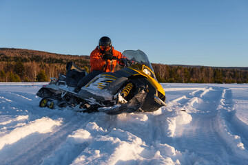 Athlete on a snowmobile moving in the winter forest in the mountains of the Southern Urals