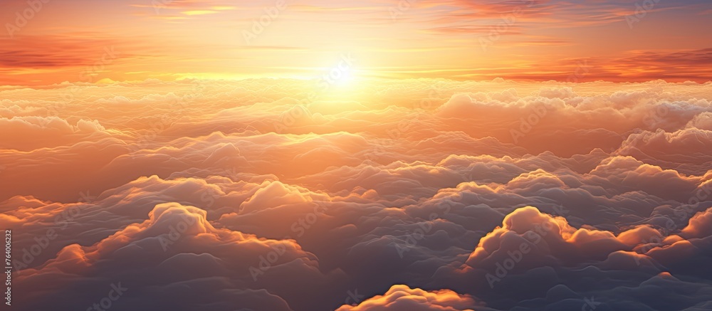 Poster an aerial view captures the setting sun casting a warm glow on a vast expanse of clouds below, creat