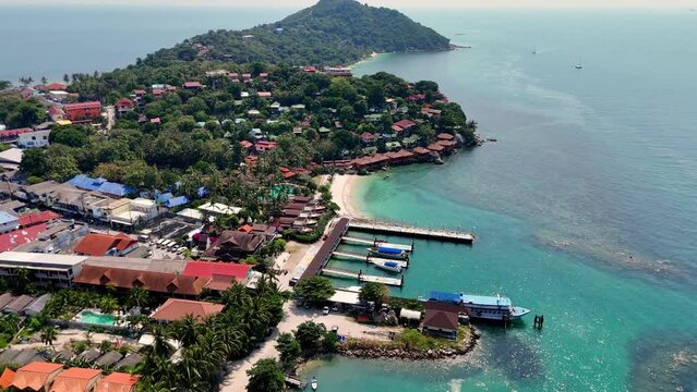 Aerial view of Haad Rin District and Haad Rin Pier (Haad Rin Queen Ferry) in Koh Phangan, Thailand. Backward drone shot.  