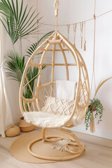 A wooden swing chair with a white blanket draped over it