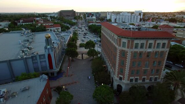Aerial Shot Of Golden Ball On Culver Theatre In City, Drone Flying Backwards During Sunset - Culver City, California