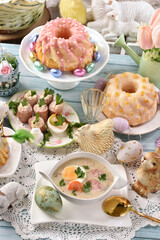 Easter table with traditional white borscht, sausage with horseradish and pastries