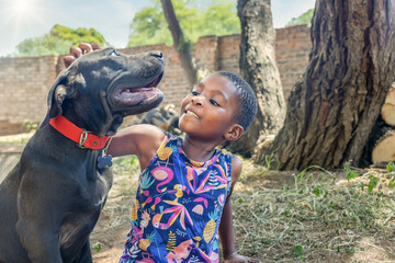 african girl playing with her boerboel dog in the garden
