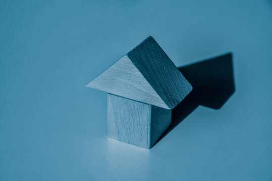 Minimal blue house made of toy wooden blocks on blue background. Housing, loan, mortgage, buying concept. Real estate business related. New home ownership.