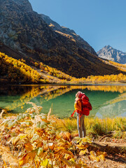 Woman hiker enjoying at lake in mountains. Lake and hiker lady with backpack