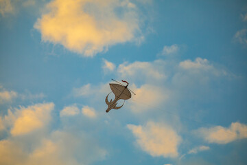 Sunset colourful kite in the sky with fluffy clouds and orange