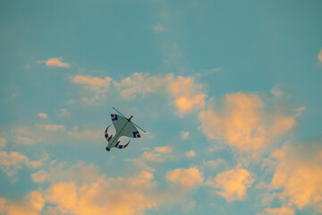 Sunset colourful kite in the sky with fluffy clouds and orange