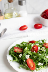Green vegan salad with arugula leaves and cherry tomatoes. Snack, food