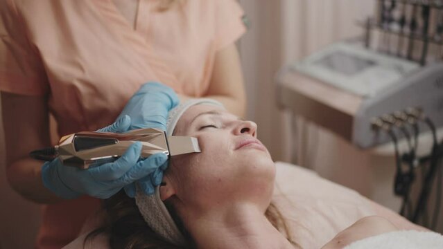 A serene client receives a galvanic facial treatment to enhance skin health and beauty, with an aesthetician performing iontophoresis.
