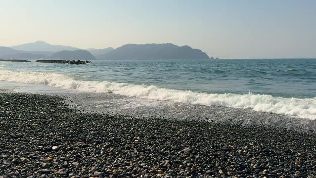 Stone beach and sea wave on Japanese seashore