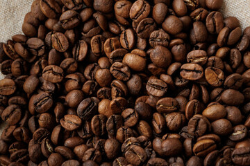 coffee beans are on table after roasting. Fresh converted coffee beans before packing in paper bag. Ground coffee for making Americano or cappuccino. grain cultivation and harvesting