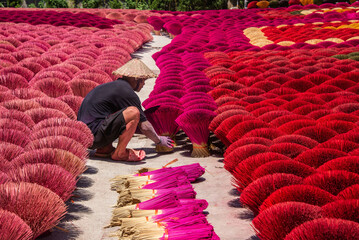 Worker drying incense in the Quang Phu Cau incense village, Hanoi, Vietnam - obrazy, fototapety, plakaty