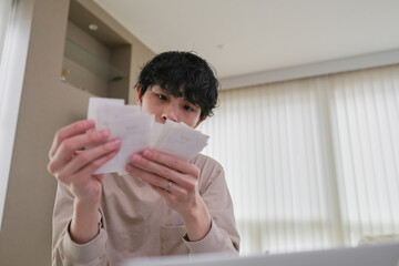 確定申告のために領収書を整理する男性のクローズアップ