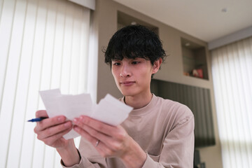 確定申告のために領収書を整理する男性のクローズアップ