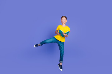Fototapeta na wymiar Photo of cheerful crazy positive nice boy bookworm wear trendy yellow clothes read book jump up isolated on violet color background