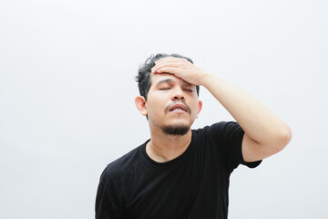 Naklejka premium an asian man shows a dizzy expression and holds his head