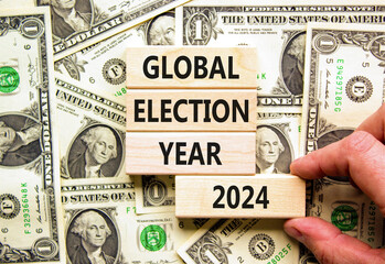 Global election year 2024 symbol. Concept words Global election year 2024 on beautiful block. Beautiful dollar bills background. Voter hand. Business Global election year 2024 concept. Copy space - obrazy, fototapety, plakaty