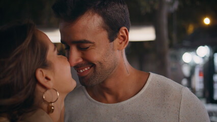 Fototapeta premium Happy couple kissing street in night closeup. Smiling lovers enjoying dating