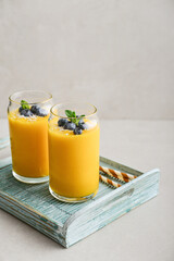 Refreshing and healthy mango smoothie with coconut flakes and fresh blueberries - 764037287