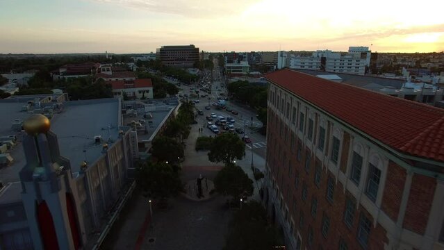 Aerial Forward Scenic View Of Culver Hotel And Theater In City Under Cloudy Sky At Sunset - Culver City, California