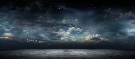 A dark sky filled with shining stars and moving clouds above an open and flat area - obrazy, fototapety, plakaty