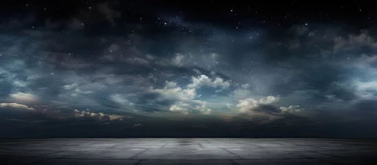 Fotobehang A dark sky filled with shining stars and moving clouds above an open and flat area © TheWaterMeloonProjec