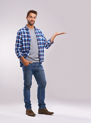 Portrait, presentation and casual man in studio with smile, deal announcement and product...