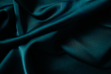 Emerald green silk or satin, draped fabric, elegant background. Beautiful wavy space for design...