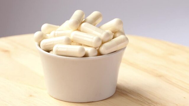 cup with pills spinning on wooden board