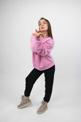 Girl athlete demonstrates the promise of a kiss by gesturing with her hands and lips, studio shot