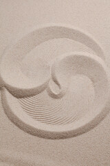 Fototapeta na wymiar Yin Yang on the sand. Yin and Yang symbol of dualism in ancient Chinese philosophy. Prints on beige sand.