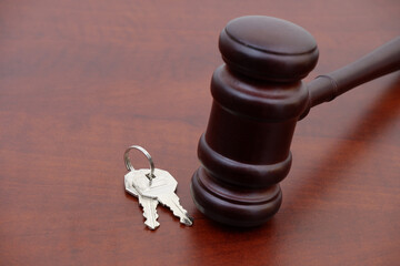 Wooden judge gavel and keys on wooden table. Laws and real estate concept. Copy space for text.