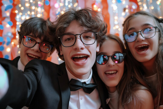 Group of teenagers having fun, taking photo together at school prom