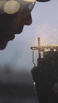 Step into the tranquil world of woodworking as a craftsman delicately clears sawdust from his saw in mesmerizing slow motion. Our 4K vertical footage captures the serene moment of craftsmanship with s