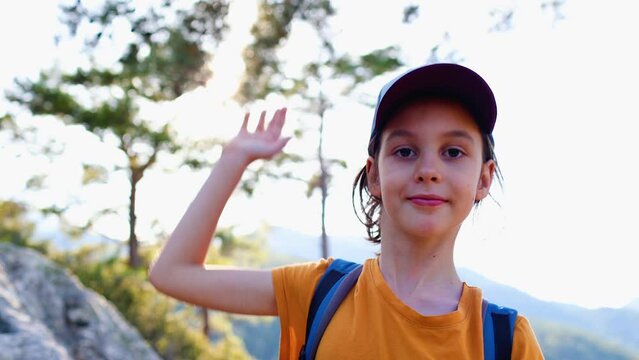 child does a high five on a hike. trip to the mountains. hiking and active healthy lifestyle. adventure holidays with children.