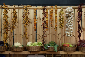 Dried peppers, garlic and herbs and fresh vegetables attractively arranged in a market in Tbilisi,...