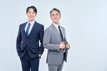 A young office worker man wearing a suit and glasses and a middle-aged man are posing with a variety of confident expressions together.