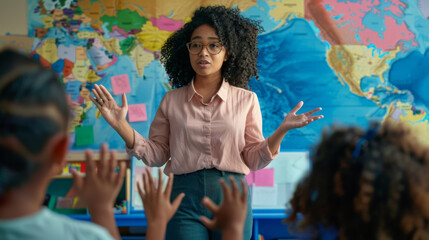 Fototapeta premium A teacher stands in front of a classroom with a world map background, engaging with students raising their hands.