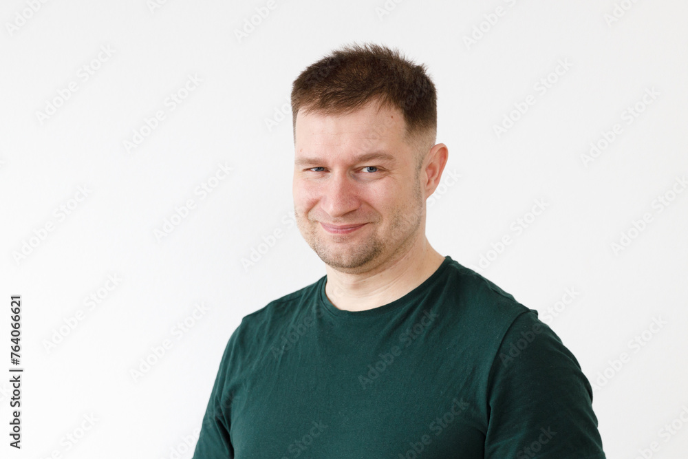 Wall mural a man in a green t-shirt shows emotions in front of the camera