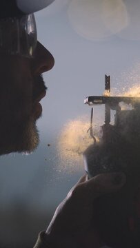 Immerse yourself in the symphony of woodworking as our 4K vertical slow motion video captures the graceful gesture of a craftsman blowing sawdust from his saw. Perfect for showcasing the elegance and 