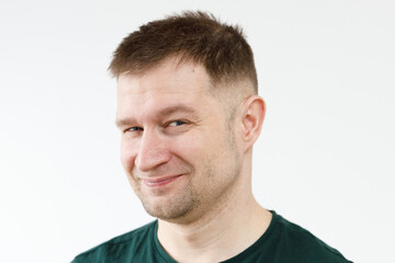 Fototapeta premium A man in a green T-shirt shows emotions in front of the camera