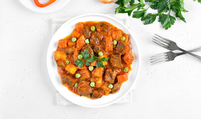 Beef stew with potatoes and carrots in tomato sauce