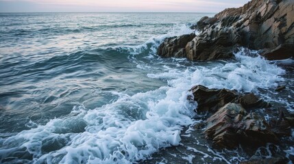 Waves crashing on rocky shoreline at dusk