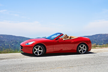 Woman, red convertible and road trip on mountain, travel and luxury transport on summer drive. Happy female person, holiday and countryside wellness on street, vacation and adventure in vehicle