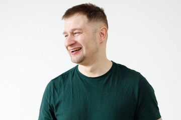 A man in a green T-shirt shows emotions in front of the camera