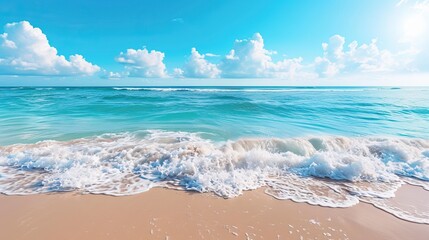 Sunny summer day at the beach with clear blue skies, sand, and ocean waves



