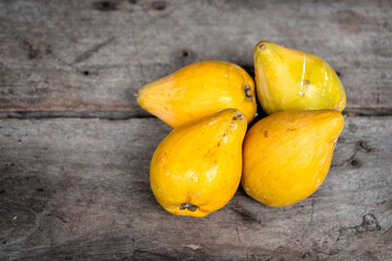 Yellow fruits are named Canistel, Egg fruit, Tiesa, Yellow sapote, Canistelsapote, Chesa(Philippines), Laulu lavulu or Lawalu (Sri Lanka) on the old rustic wooden table.