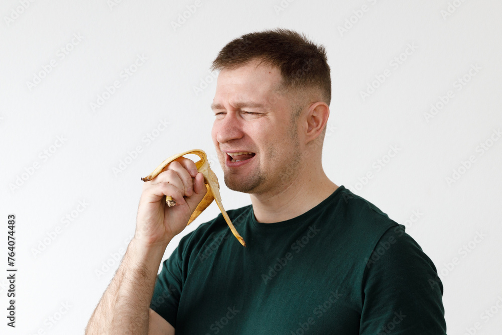 Wall mural a man in a green t-shirt shows emotions in front of the camera