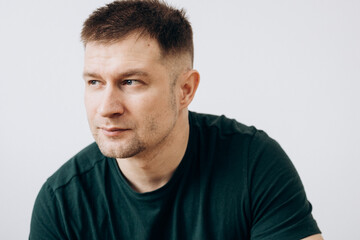 Fototapeta premium A man in a green T-shirt shows emotions in front of the camera