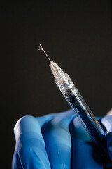 Doctor holds a syringe with an injection with his gloved hand. Vaccines and vaccinations and...